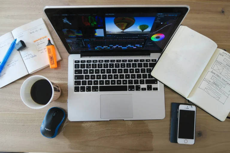 Mesa de trabalho criativa com laptop mostrando ferramentas de design, representando o Canva Magic Studio